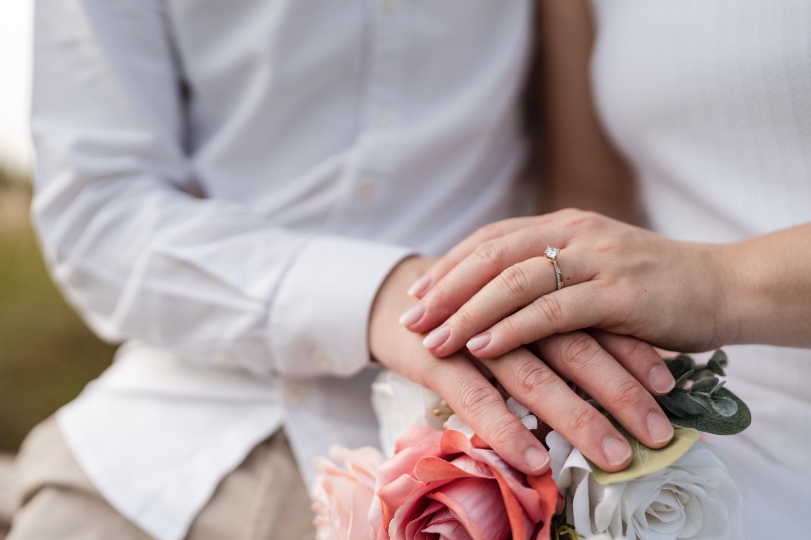Couple holding hands with wedding rings, symbolizing unity and commitment